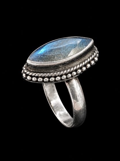 A silver-toned ring with a labradorite stone and rope-like border