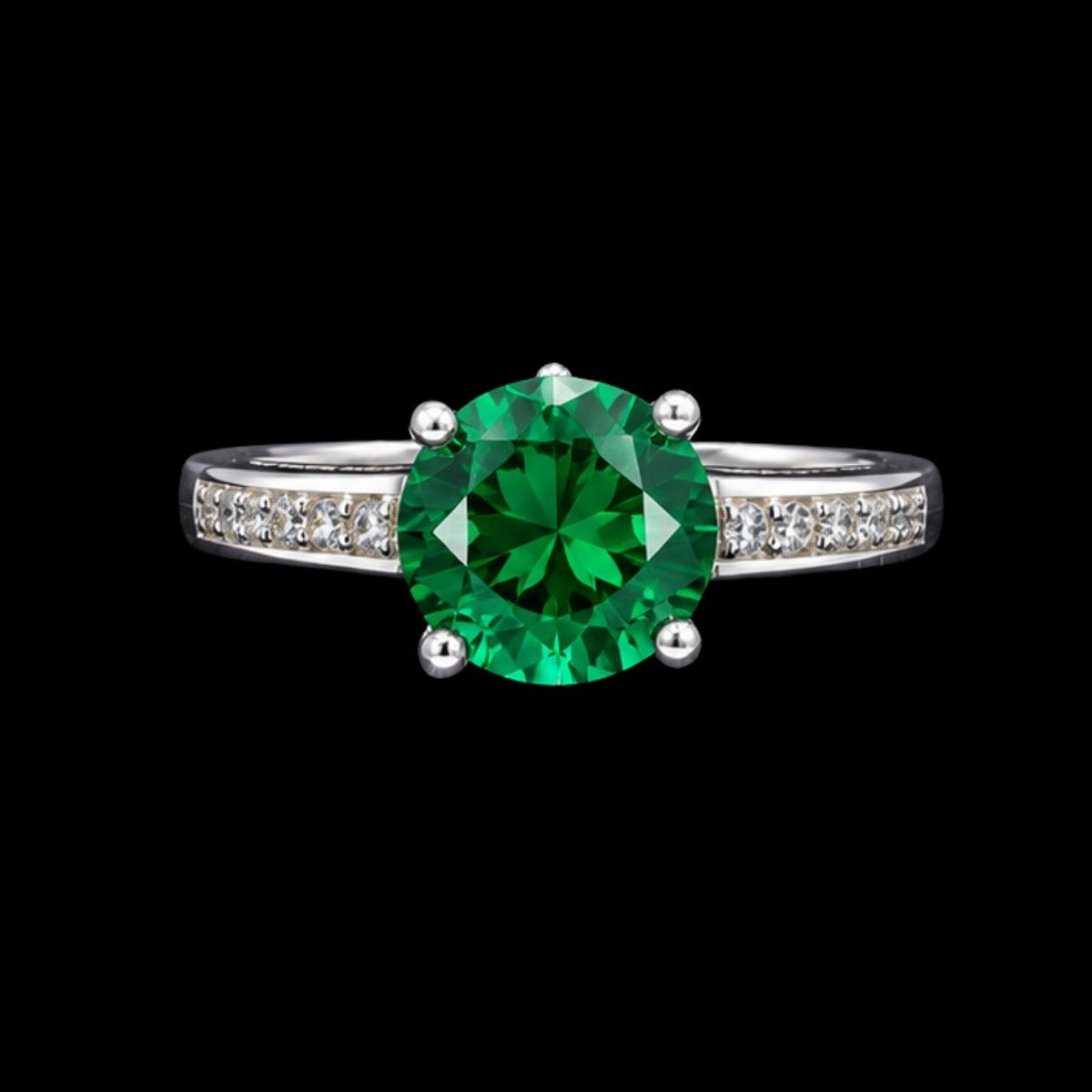 A silver ring with an emerald stone in the center, set against a plain background.