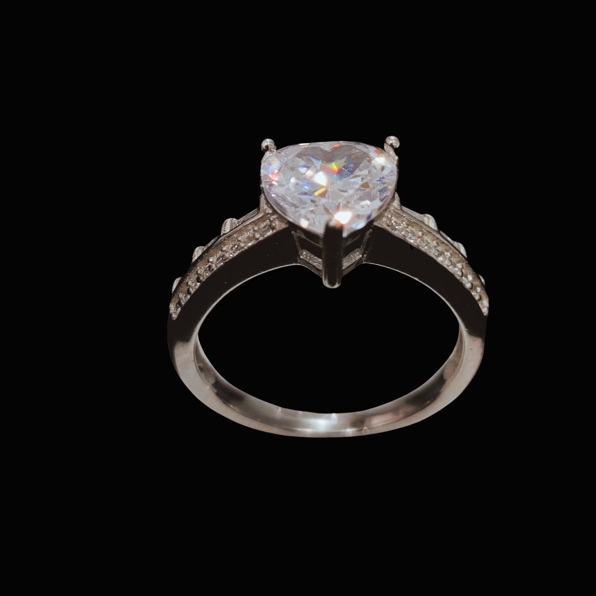 A silver ring with a heart-shaped CZ stone, set on a plain background.