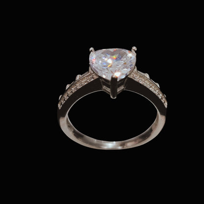 A silver ring with a heart-shaped CZ stone, set on a plain background.