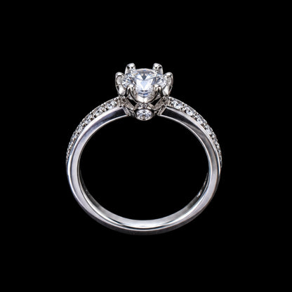 A silver-tone ring with a round-cut cubic zirconia stone at its center, surrounded by smaller stones on the band.