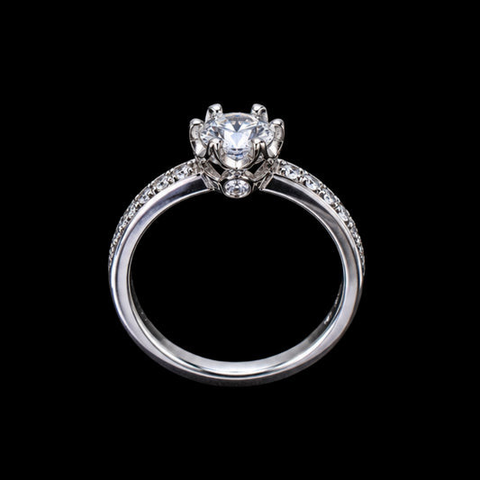 A silver-tone ring with a round-cut cubic zirconia stone at its center, surrounded by smaller stones on the band.