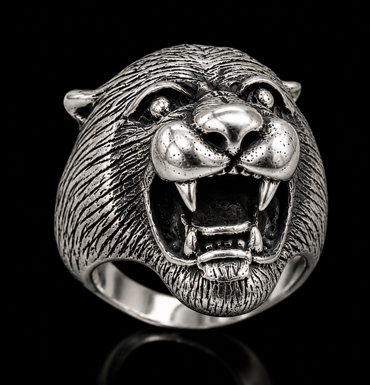 A silver ring with a tiger design and CZ stones, set against a black background.