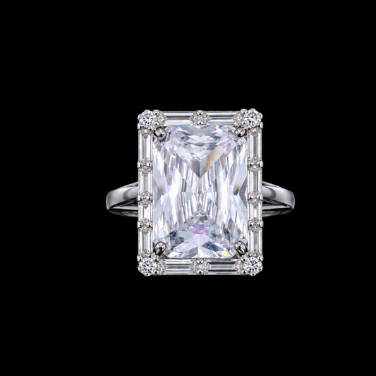 A silver ring with a large radiant-cut cubic zirconia stone and smaller stones set in a silver band.