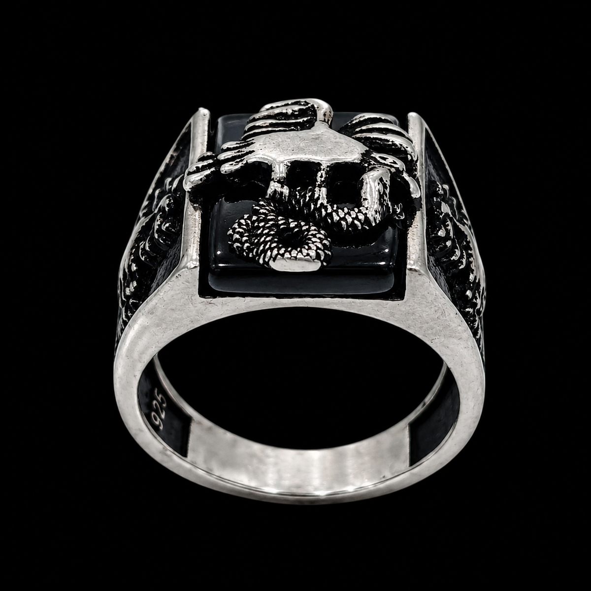 A silver ring with a lion design on a black background.