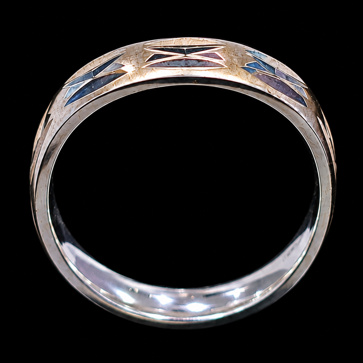 A silver ring with enamel work, featuring a geometric design and CZ stones.
