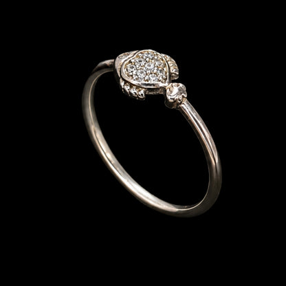 A silver ring with enamel work and CZ stones on a plain background