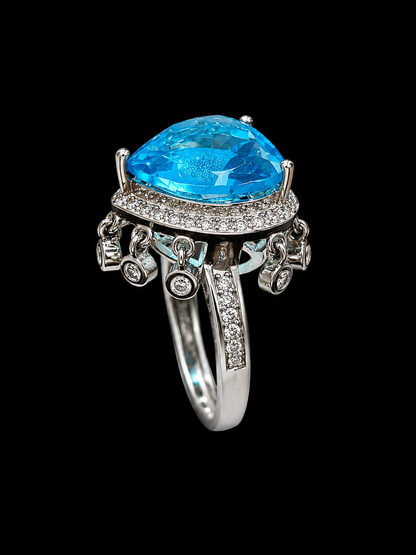 A silver-tone ring with a large blue gemstone and clear stones.