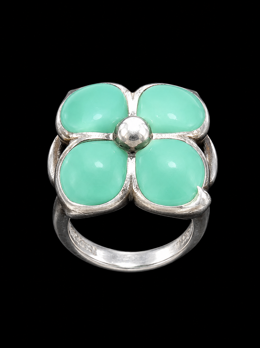 A silver ring with a floral design and mint green stones.
