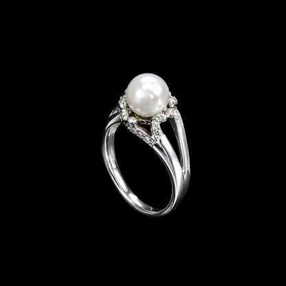 A silver-tone ring with a pearl and CZ stones on a black background.