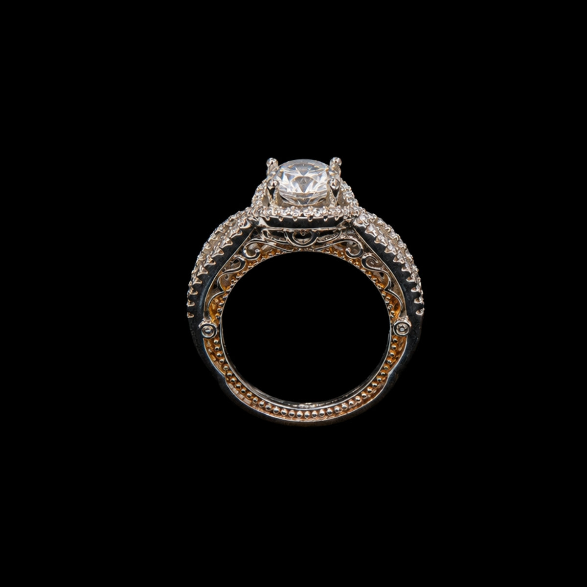 A silver ring with a round CZ stone, featuring an ornate design.