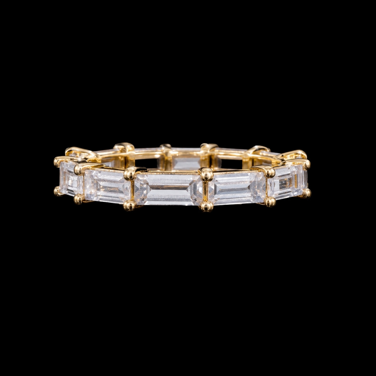 A gold-tone ring featuring a row of clear CZ stones set in a gold-tone setting.