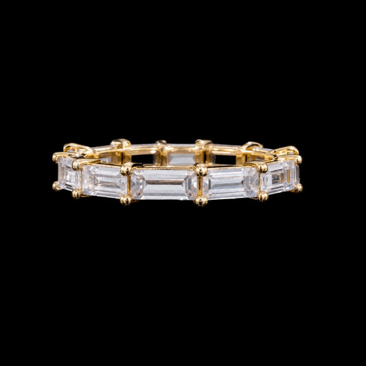A gold-tone ring featuring a row of clear CZ stones set in a gold-tone setting.