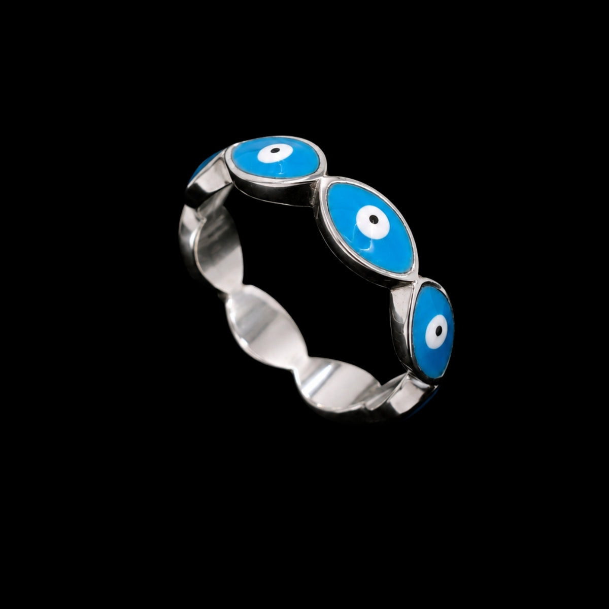 A silver ring with three blue enamel evil eye motifs, each with a white center and black pupil.