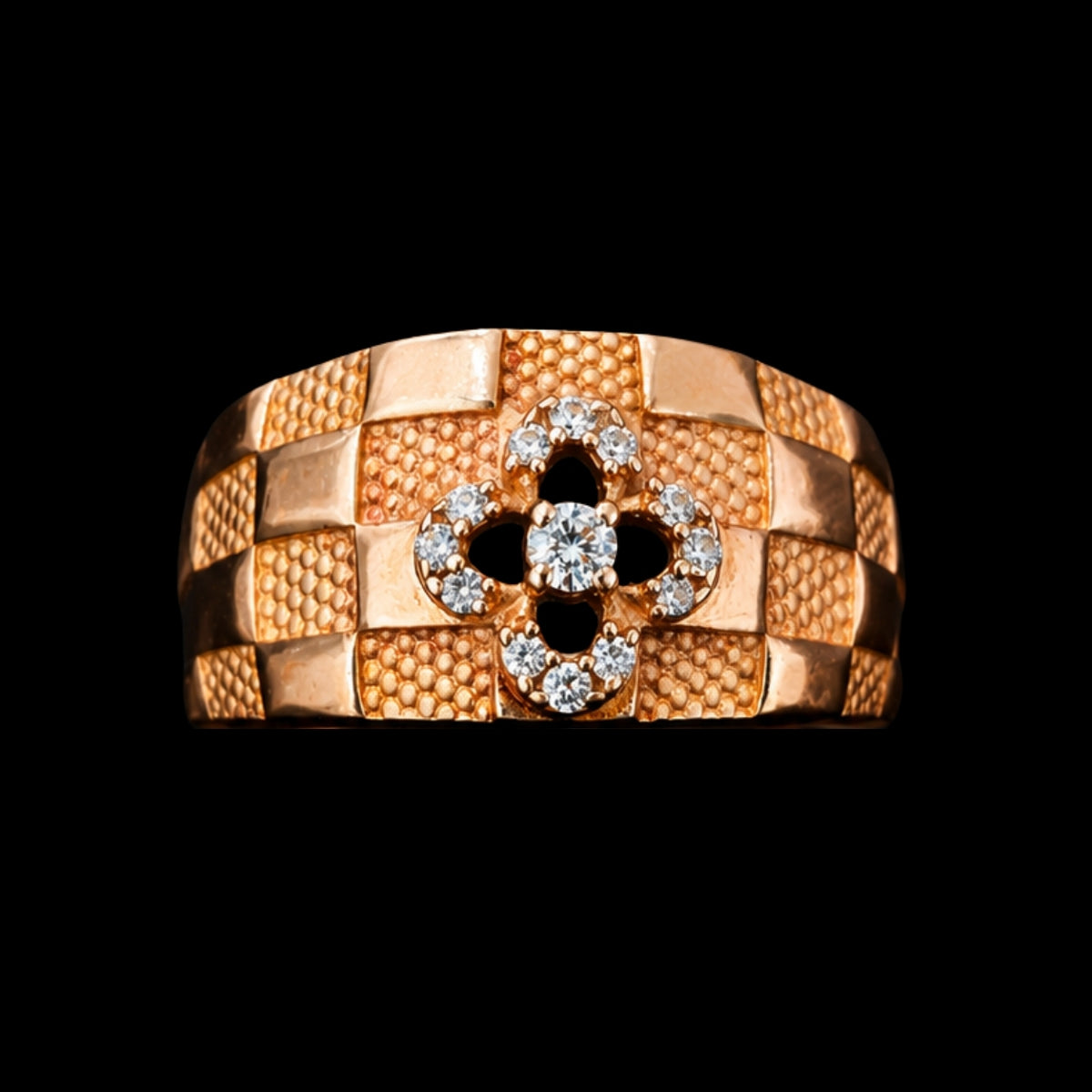 A gold-tone ring with a textured band and a central CZ stone motif.