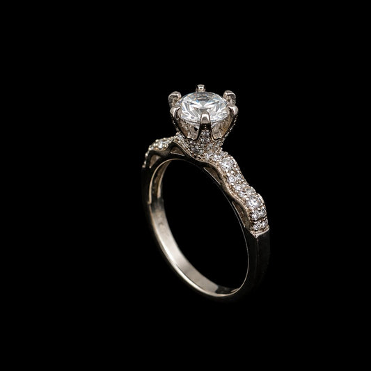 A silver-tone ring with a large round-cut CZ stone at its center, surrounded by smaller CZ stones along the band.