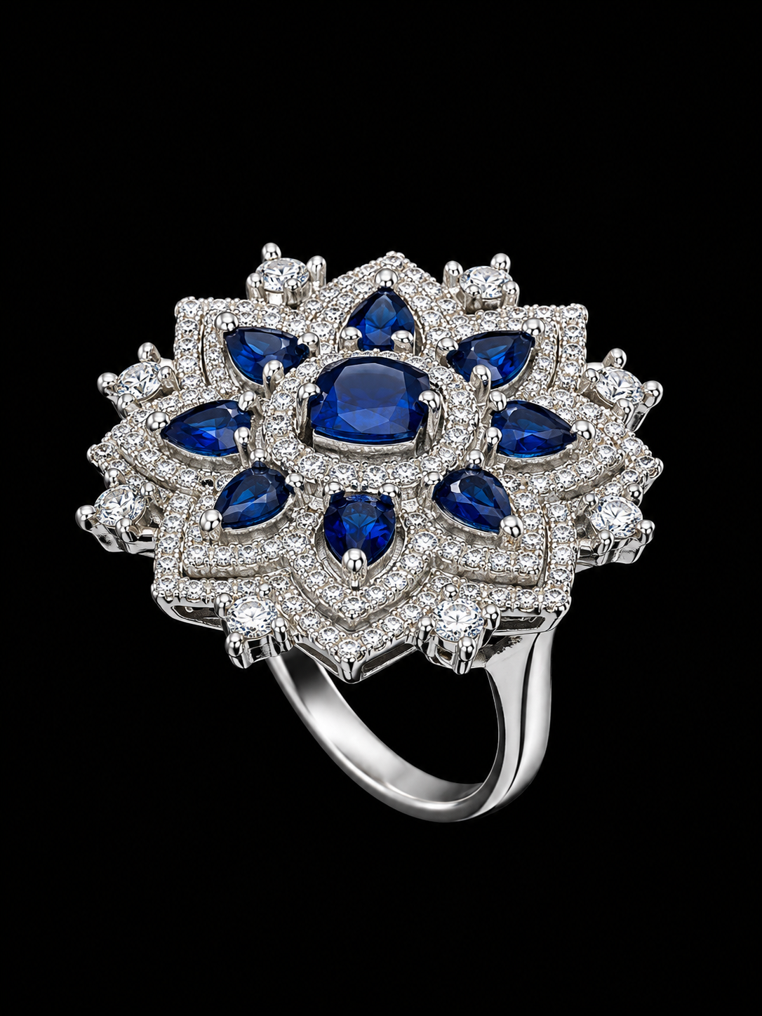 A silver ring with a floral design and blue CZ stones.