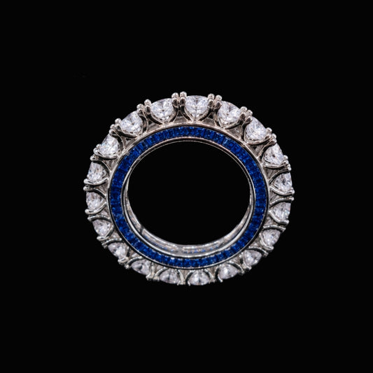 A silver-tone ring with a blue CZ stone surrounded by white CZ stones.