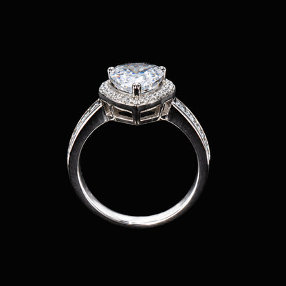 A silver ring with a large CZ stone and smaller accent stones, set against a plain background.