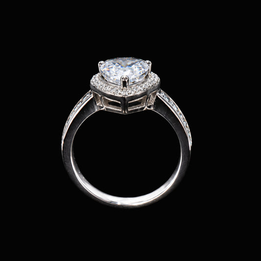 A silver ring with a large CZ stone and smaller accent stones, set against a plain background.