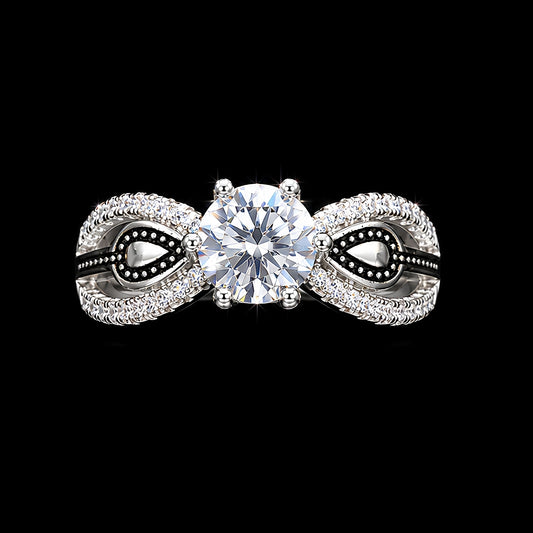 A silver-tone ring with a large round-cut CZ stone and smaller stones, set against a dark background.