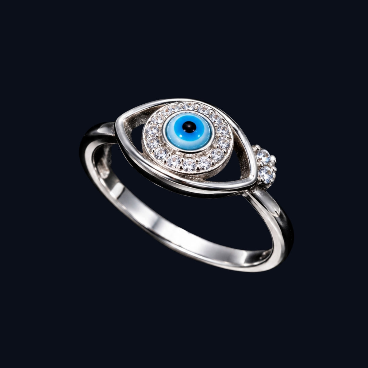 A silver-tone ring with a blue enamel evil eye design and clear CZ stones.