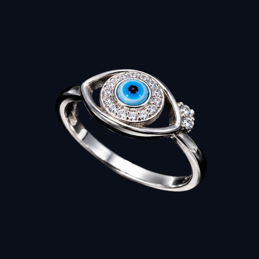 A silver-tone ring with a blue enamel evil eye design and clear CZ stones.