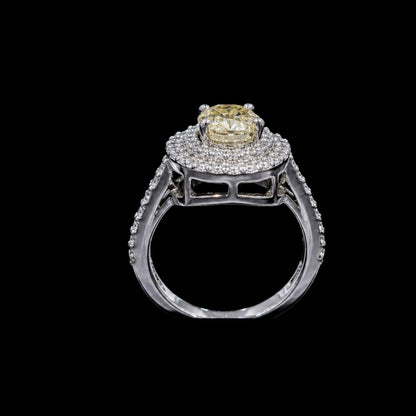 A silver tone ring with a round cut CZ stone at its center, surrounded by a halo of smaller stones.