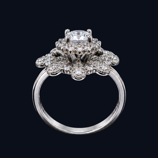 A silver ring with a floral design and CZ stones, set against a dark background.