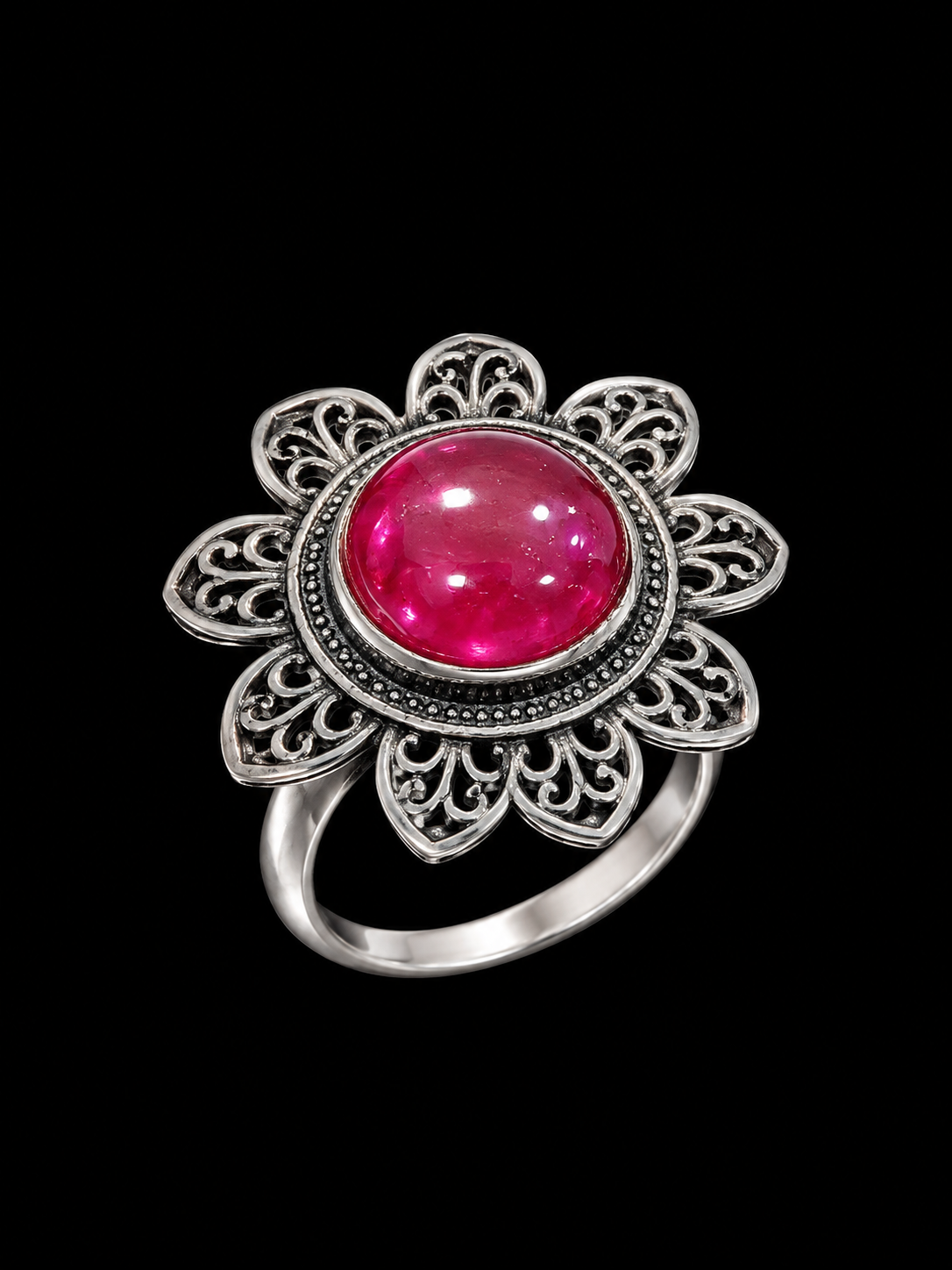 A silver-tone ring with a pink stone and floral design.