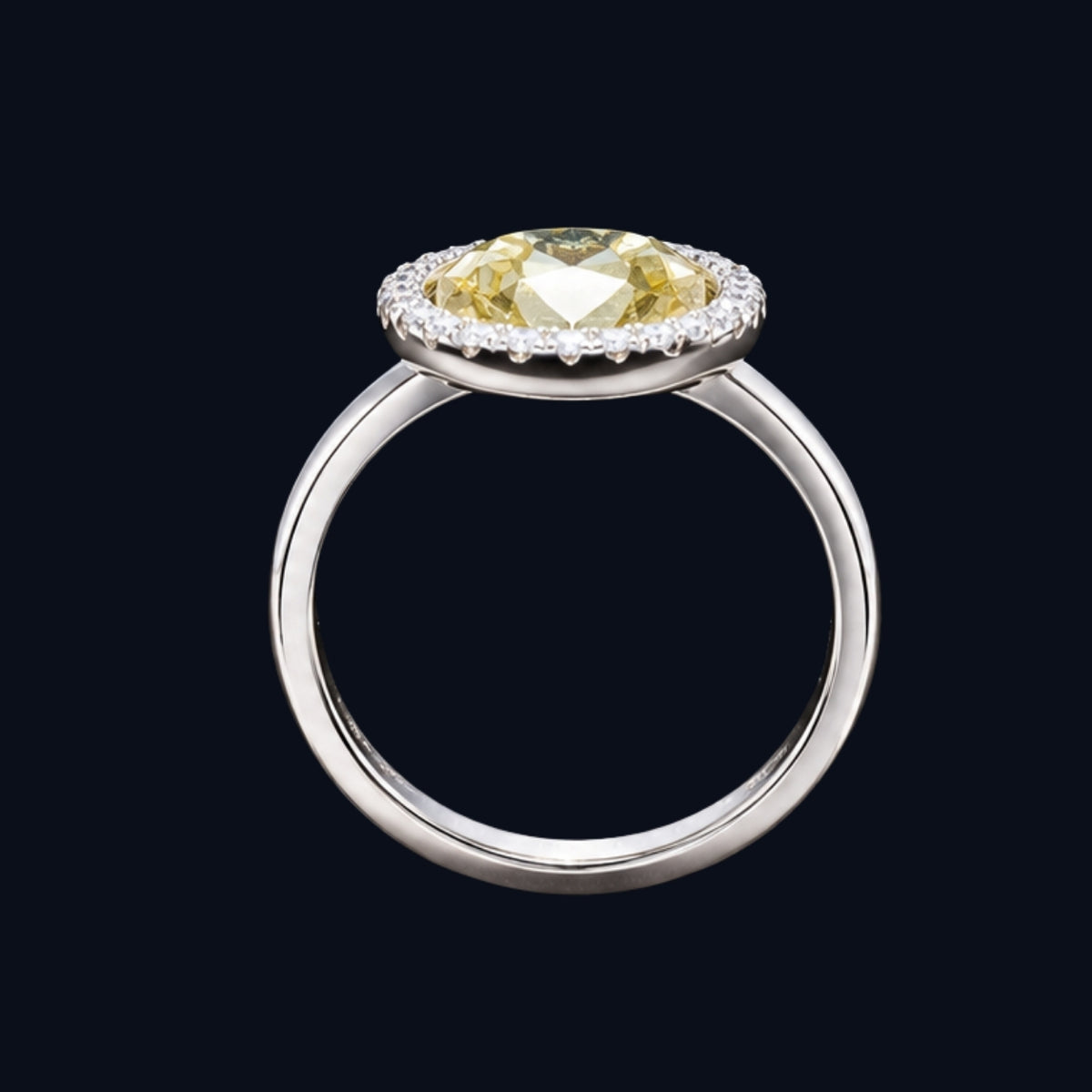 A silver ring with a yellow CZ stone in the center, surrounded by a halo of smaller CZ stones.
