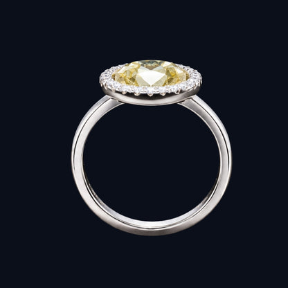 A silver ring with a yellow CZ stone in the center, surrounded by a halo of smaller CZ stones.