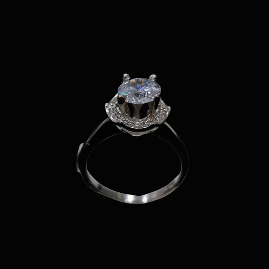 A silver-tone ring with a round-cut CZ stone on a black background
