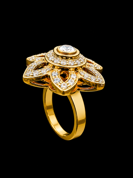 A gold-tone ring with a central CZ stone and intricate filigree design.