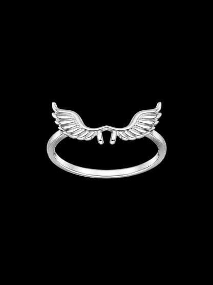 A silver ring with a wing design on a plain background