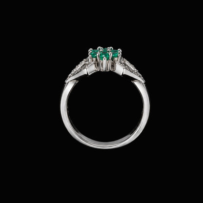 A silver-tone ring with three emerald stones and CZ accents.