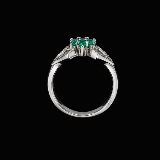 A silver-tone ring with three emerald stones and CZ accents.