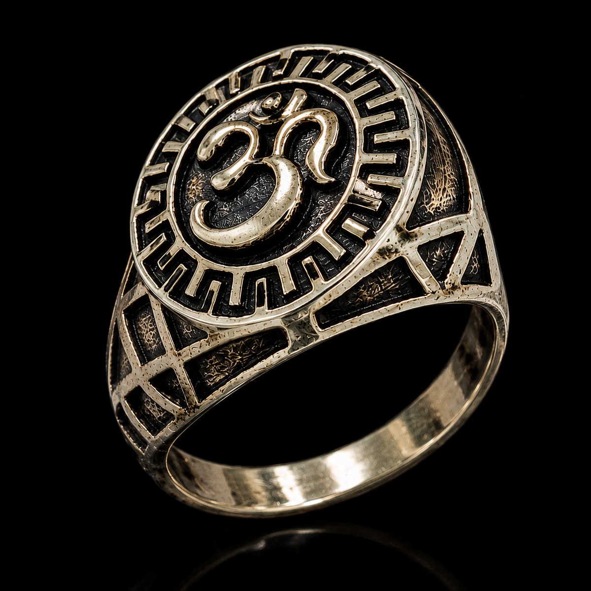 A silver ring with an engraved Om symbol on a black background