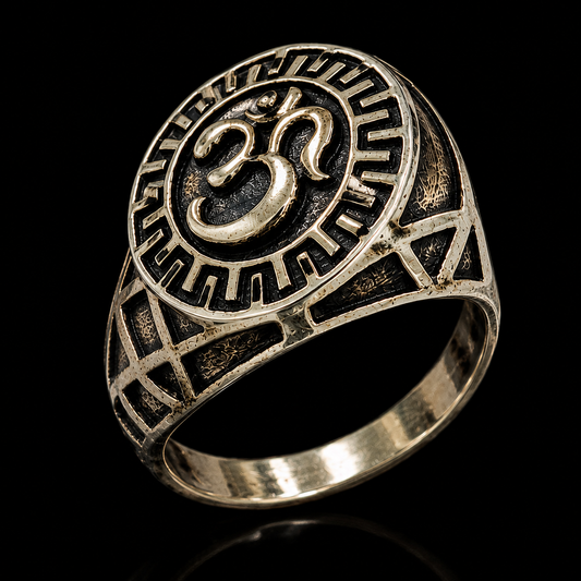 A silver ring with an engraved Om symbol on a black background