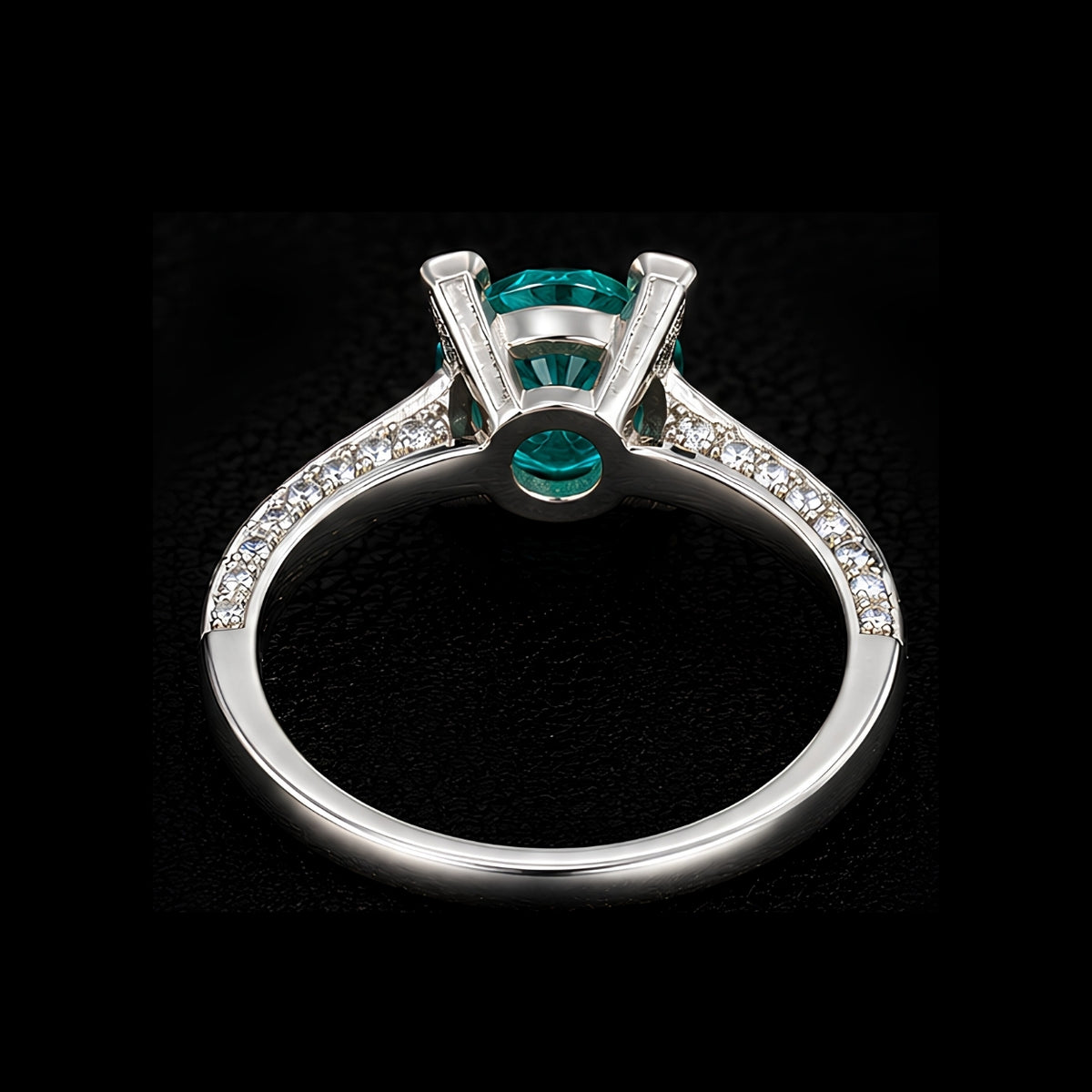 A silver ring with an emerald-cut stone, set in a minimalist geometric design.