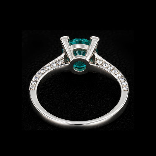 A silver ring with an emerald-cut stone, set in a minimalist geometric design.