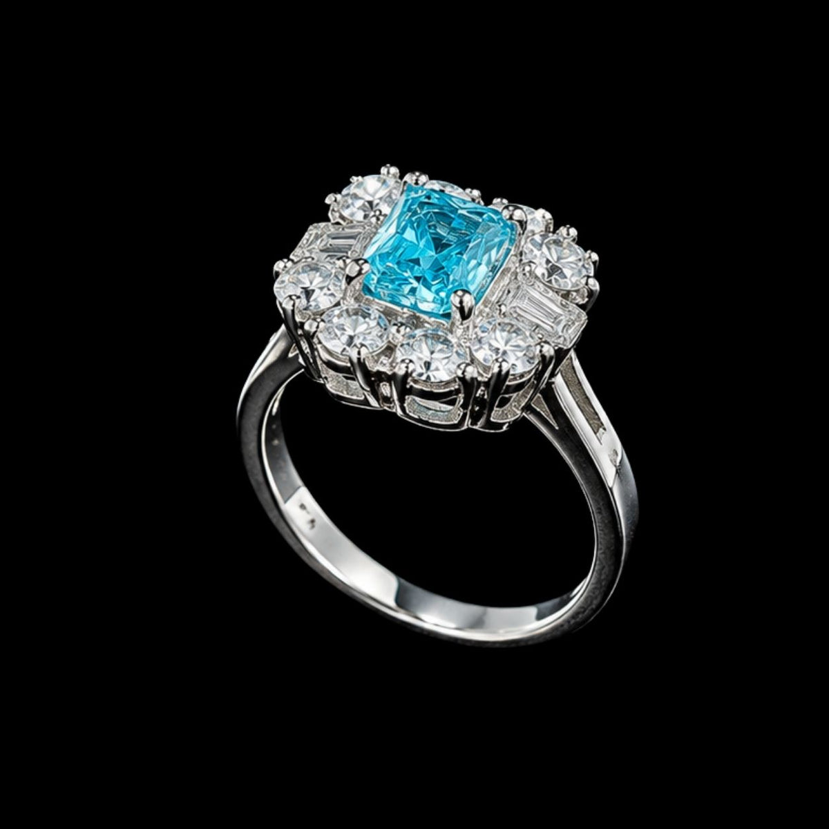 A silver ring with a blue gemstone and CZ stones on a black background.