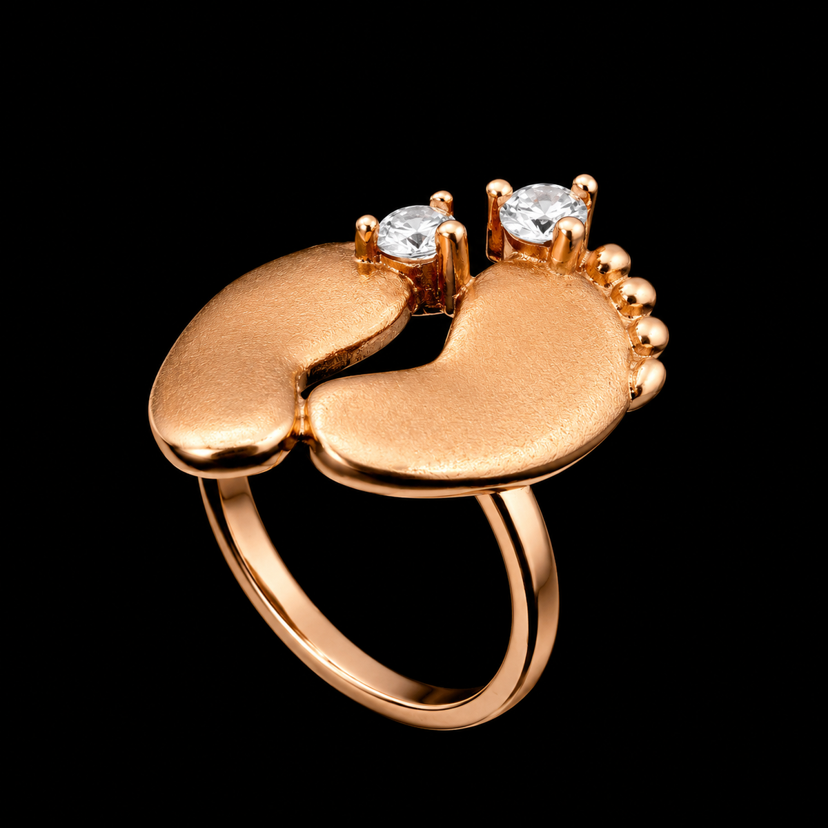 A gold ring with two baby feet and cubic zirconia stones
