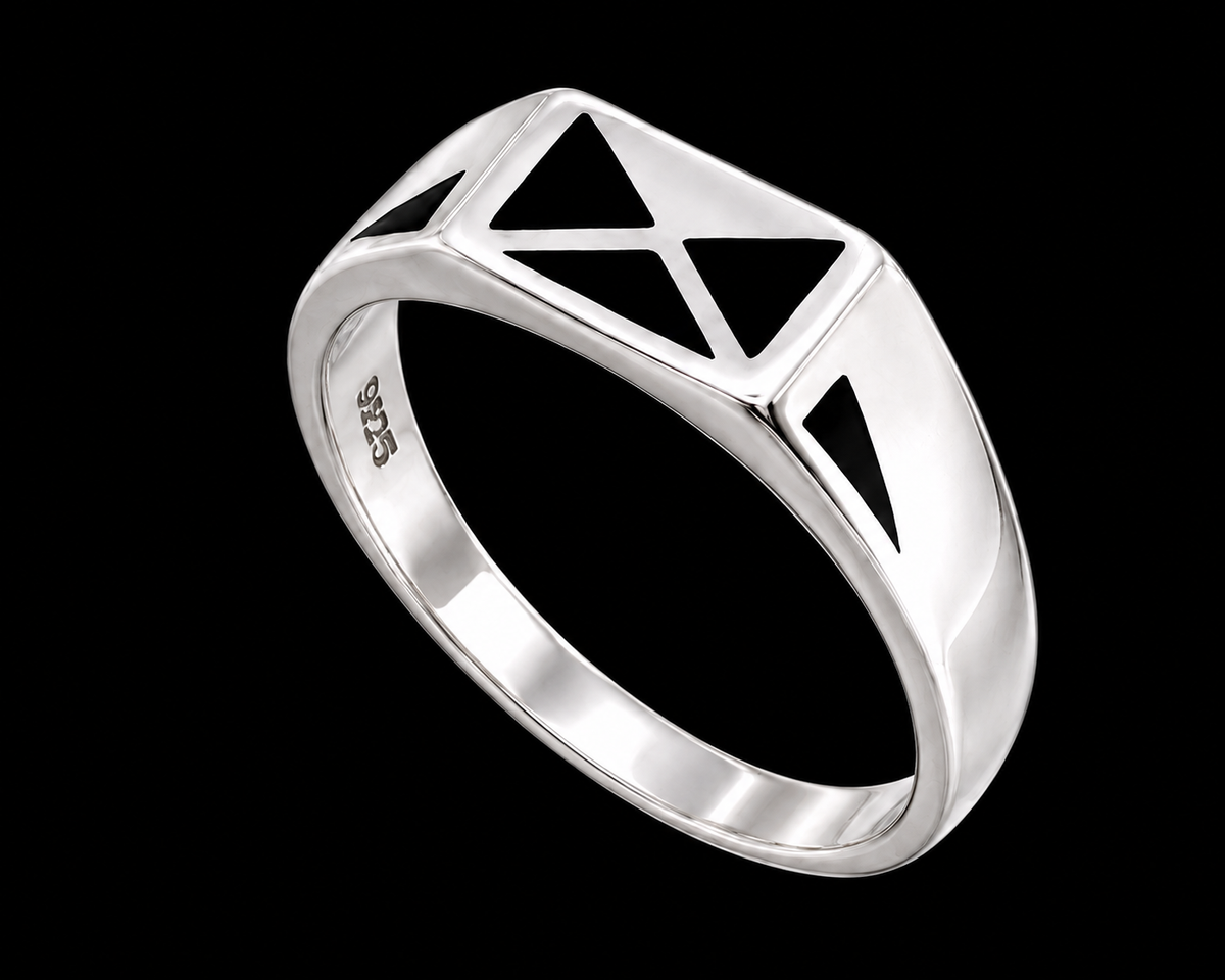 A silver ring with a geometric pattern on a gray background