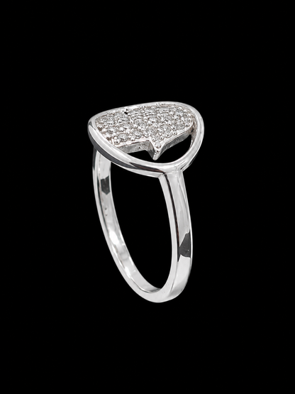 A silver ring with a CZ stone design, set against a light gray background.