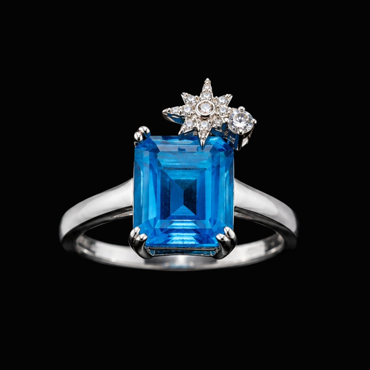 A silver ring with a large blue gemstone and a star motif.