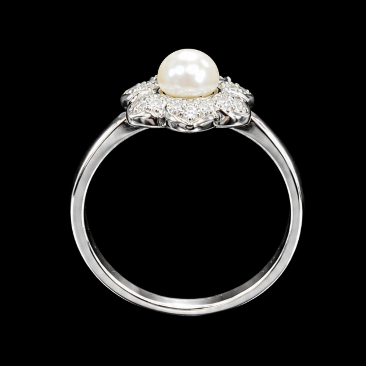 A silver ring with a pearl and floral design