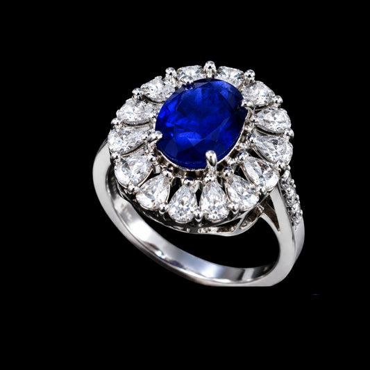 A silver-tone ring with a large blue sapphire stone and smaller clear stones.