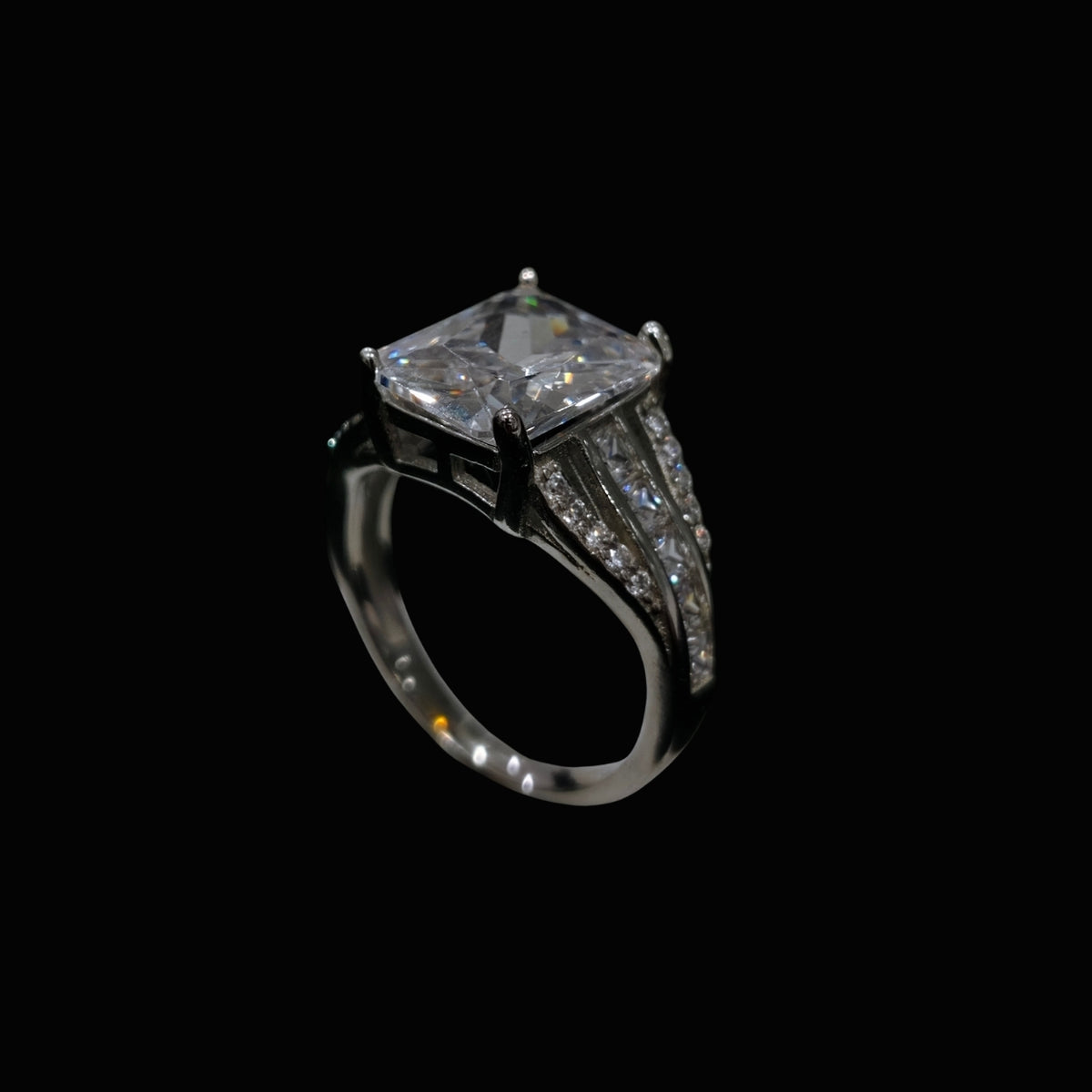 A silver-tone ring with a large clear CZ stone and smaller CZ stones along the band.