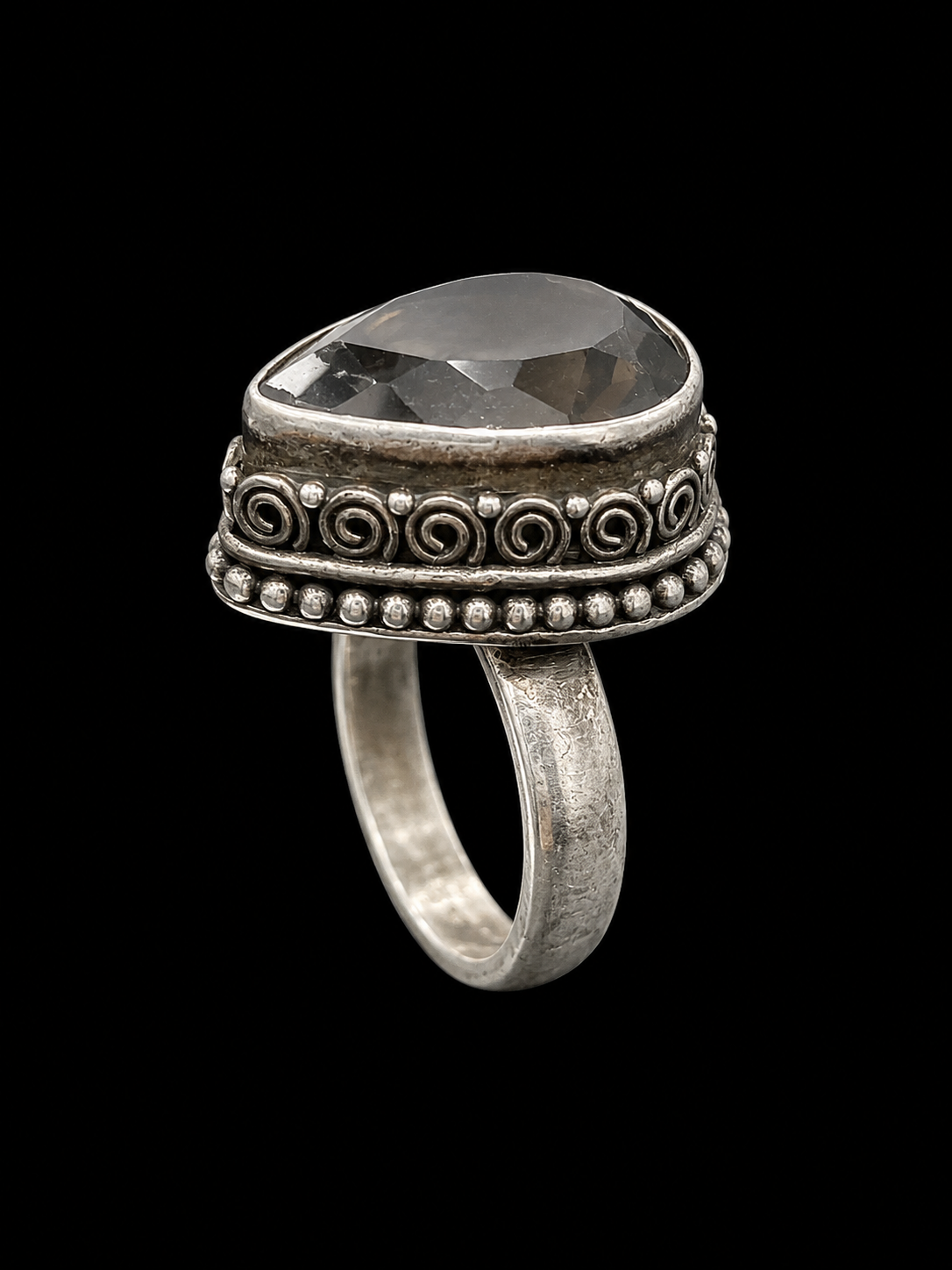 A silver ring with a large, clear CZ stone at its center, set against a plain background.
